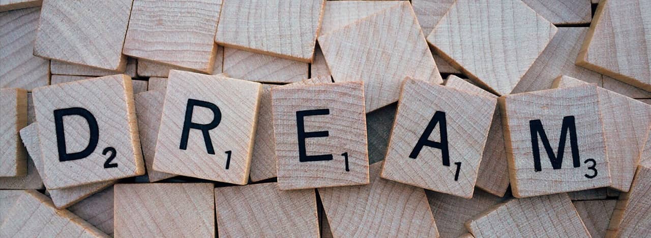A photo of scrabble tiles that spell out DREAM